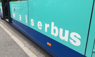 Ein Bus mit der Aufschrift "walserbus". Die Farbe des Busses ist hauptsächlich grün und blau. | © Kleinwalsertal Tourismus