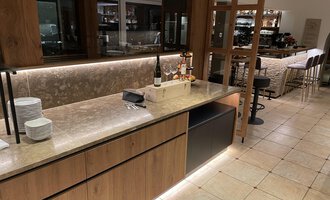 A modern bar with wood and stone details. The room is bright and inviting, with a spacious seating area in the background. | © Almhof Rupp | Lukas Kind