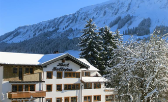 A picturesque hotel in the snow with majestic mountains in the background. The landscape is wintry and calm, perfect for a holiday in the mountains. | © Hotel Bellevue | I. Malouvier