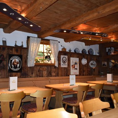 Ein gemütliches Restaurant mit Holzmöbeln und rustikalem Ambiente. Die Wände sind geschmückt mit dekorativen Tellern und Bildern. | © s‘Älpele | Marco Mitterer