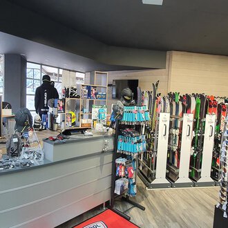 Ein Sportgeschäft mit Ski- und Snowboardausrüstung. Im Hintergrund sind Sonnenbrillen und andere Zubehörartikel angeboten. | © Ski + Sport Zunzer Mittelberg