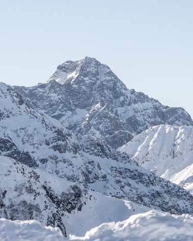Panoramic view of the snow-covered Widderstein peak and surrounding mountains in winter scenery. | © Kleinwalsertal Tourismus eGen • Photographer: Dominik Berchtold