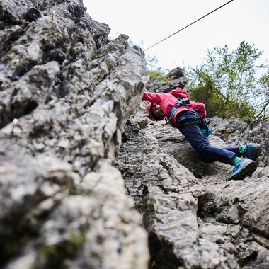 Person beim Klettern an einer Felswand bei Bergschule Kleinwalsertal, Sommer 2023. | © Kleinwalsertal Tourismus eGen • Fotograf: Oliver Farys
