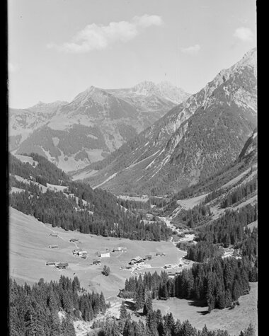 Beautiful mountain landscape in the valley with small farms, surrounded by high peaks, in a historic black-and-white photo. | © Kleinwalsertal Tourismus eGen • Karl Max Kessler Archiv
