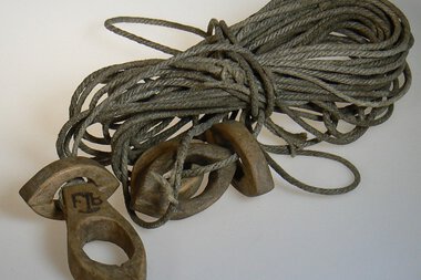 Historical mining tool with rope and wooden picks, used for extraction, on a white background. | © Kleinwalsertal Tourismus eGen • Stefan Heim