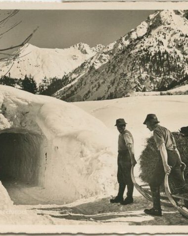 Two men in front of a snow tunnel in a snowy mountain landscape, historical photograph. | © Kleinwalsertal Tourismus eGen • Stefan Heim