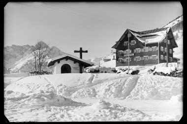 Snow-covered area with chapel and house in the mountains, winter, historic photograph. | © Kleinwalsertal Tourismus eGen • Karl Max Kessler Archiv