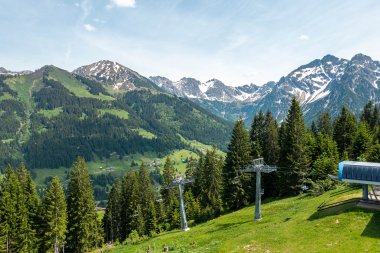 Mountain station of a cable car in the Alps with mountains, forests, and a ski lift in Oberstdorf, Germany. | © Oberstdorf · Kleinwalsertal Bergbahnen