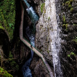 Blick vom Zwingsteig in die Breitachklamm im Sommer, enges Tal mit Wasser und Felsen, Umgeben von grüner Vegetation. | © Kleinwalsertal Tourismus eGen • Breitachklamm • Fotograf: Domink Berchtold